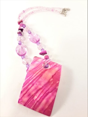 Halsband med rosa detaljer och snäckskal