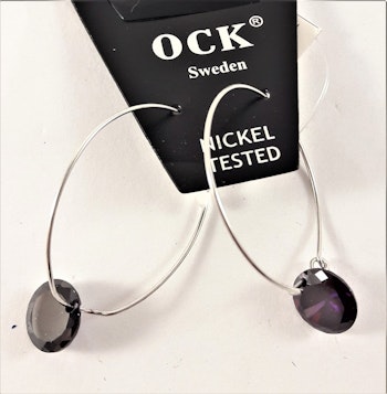 Örhängen med silverfärgad ring och lila detaljer
