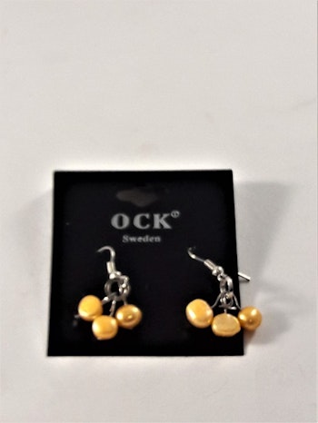 Örhänge med orange detaljer i hänget