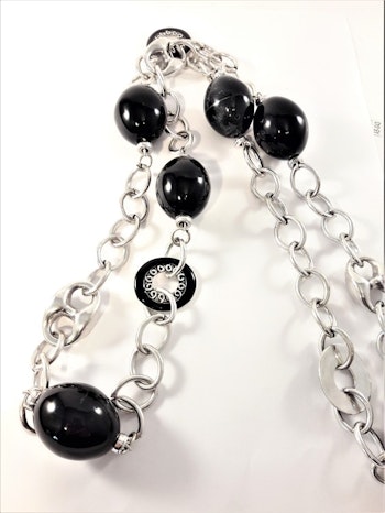 Långt halsband i silverfärg med länkar och stora kulor i svart