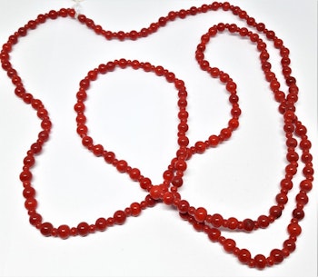 Långt halsband med små röda kulor