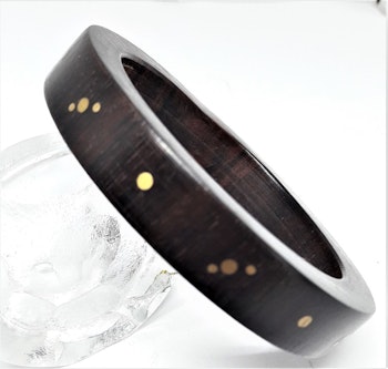 Stelt armband av trä med guldfärgat mönster