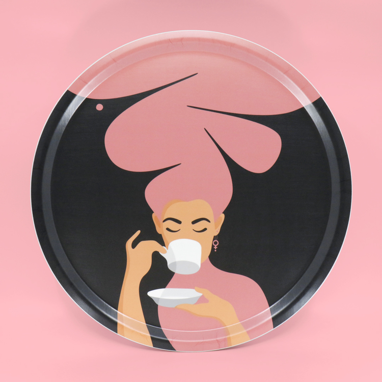 Rund bricka med motivet Kaffekvinna i rosa. Kaffekvinnan har stort böljande hår, bär ett feministörhänge och njuter av en kopp kaffe.