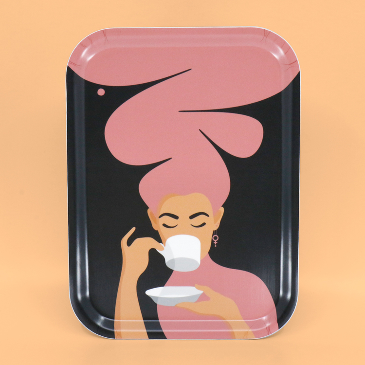 Rektangulär bricka med motivet Kaffekvinna i rosa. Kaffekvinnan har stort böljande hår, bär ett feministörhänge och njuter av en kopp kaffe.