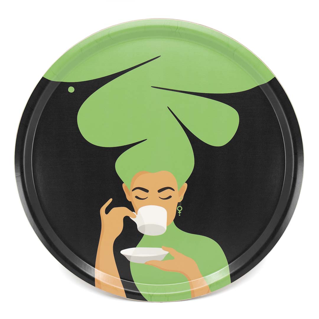 Rund grön bricka med motivet Kaffekvinnan. Kaffekvinnan har stort böljande hår, bär ett feministörhänge och njuter av en kopp kaffe.
