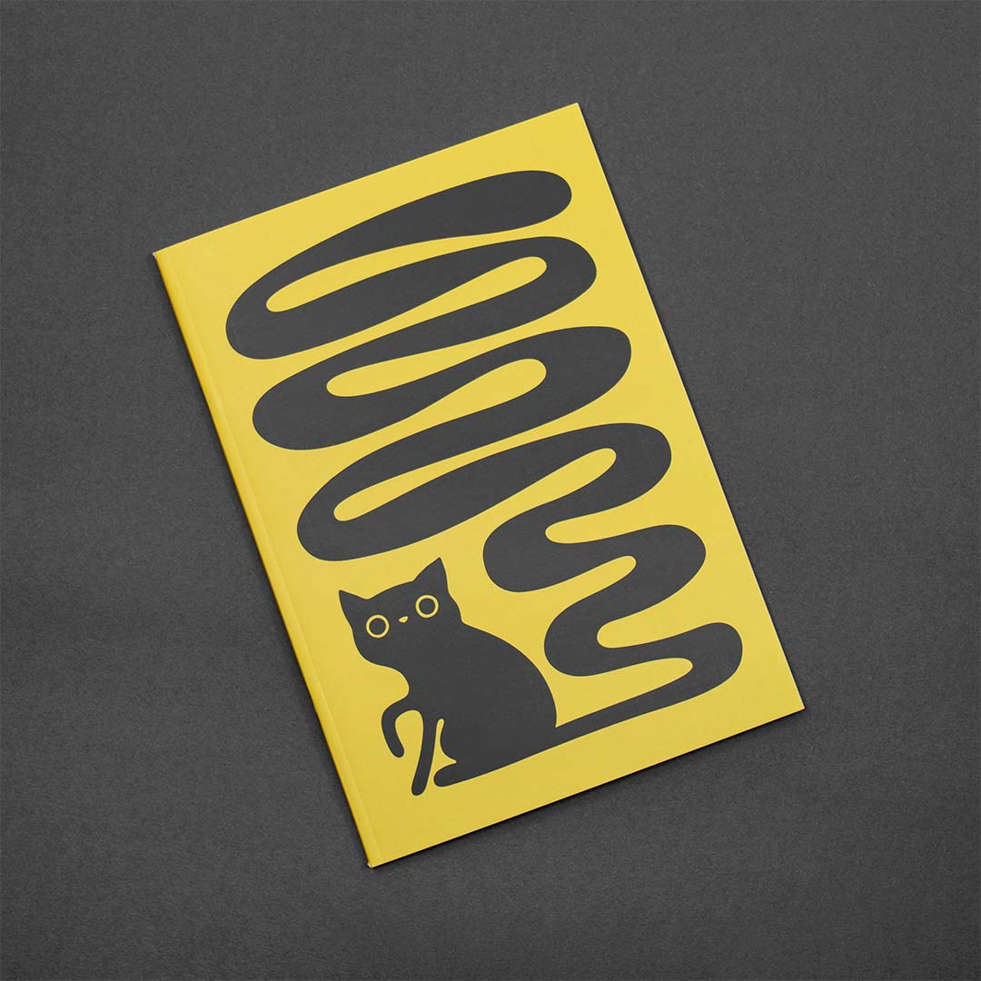 Gult ritblock / anteckningsblock med motivet Svanskatten – en svart katt med lång slingrande svans – på omslaget. Inlagan består av 36 blanka sidor i 200 g miljömärkt papper. Storlek: A5.