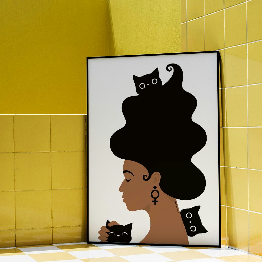 Poster med motivet Kattkvinnan – en kvinna med stort böljande hår, omgiven av tre busiga katter. Inramad i gult badrum. Färg: svartvit.