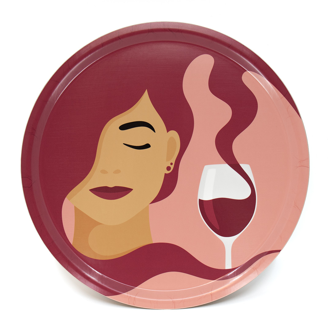 Rund bricka med motivet Tipsy – en kvinna vars hår blir till vin som rinner ner i hennes vinglas. Färg: rosa och röd.