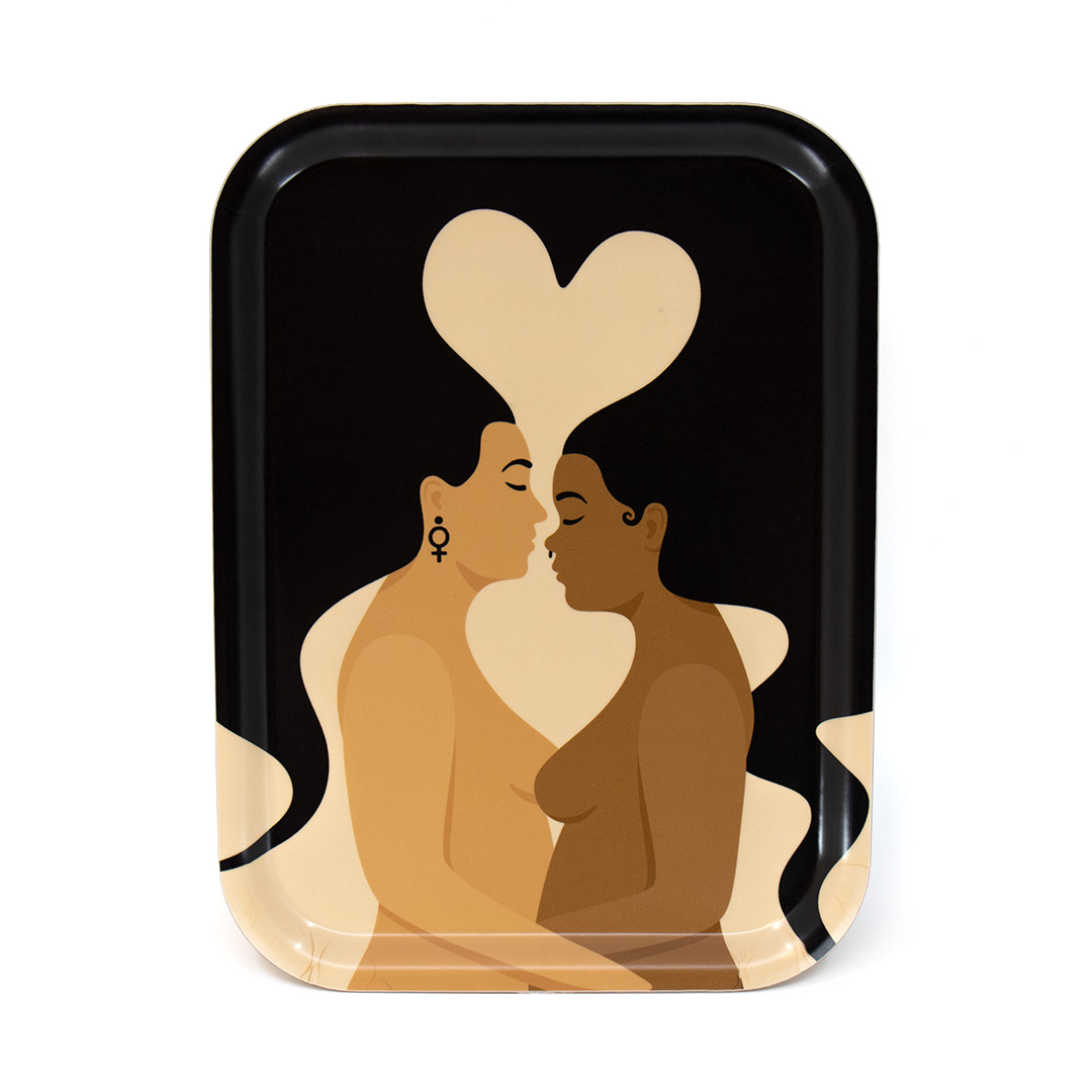 Rektangulär mindre bricka / frukostbricka med motivet Kärlek – två kvinnor som håller om varandra och vilkas hår formar ett hjärta. Färg: sand och svart.