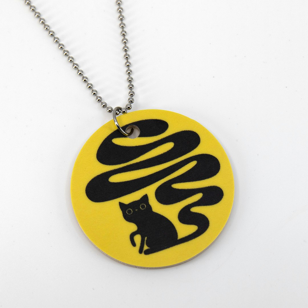 Gult halsband med motivet Svanskatten – en svart katt med lång slingrande svans. Tillverkat av miljömärkt björkfaner.