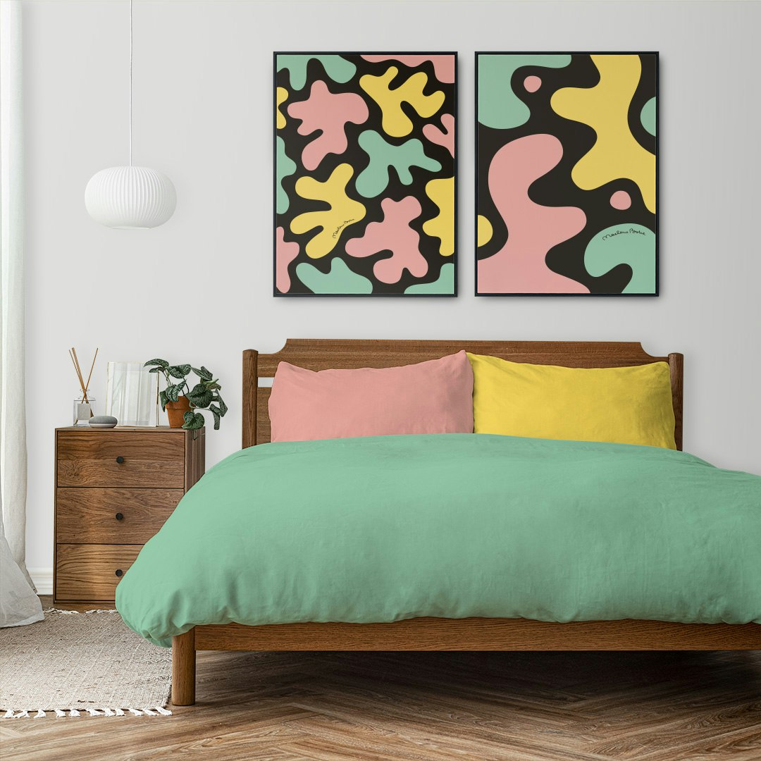 Prints / posters med dom grafiska motiven Blobbar och Kalas. Här ovanför en säng med matchande lakan. Färg: gul, mint och rosa.