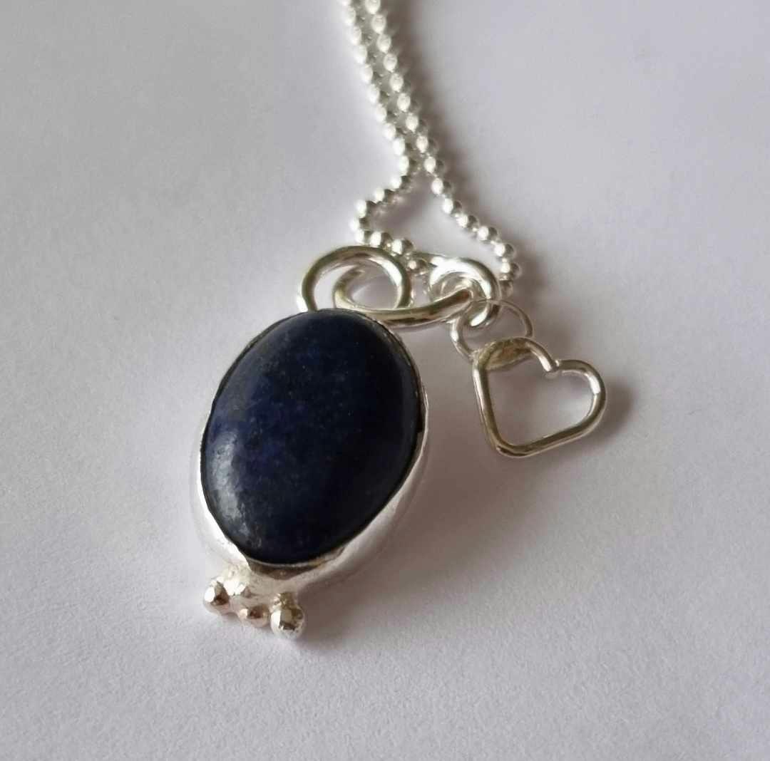 Berlock med en blå lapis infattad i äkta silver och ett pyttehjärta  halsband