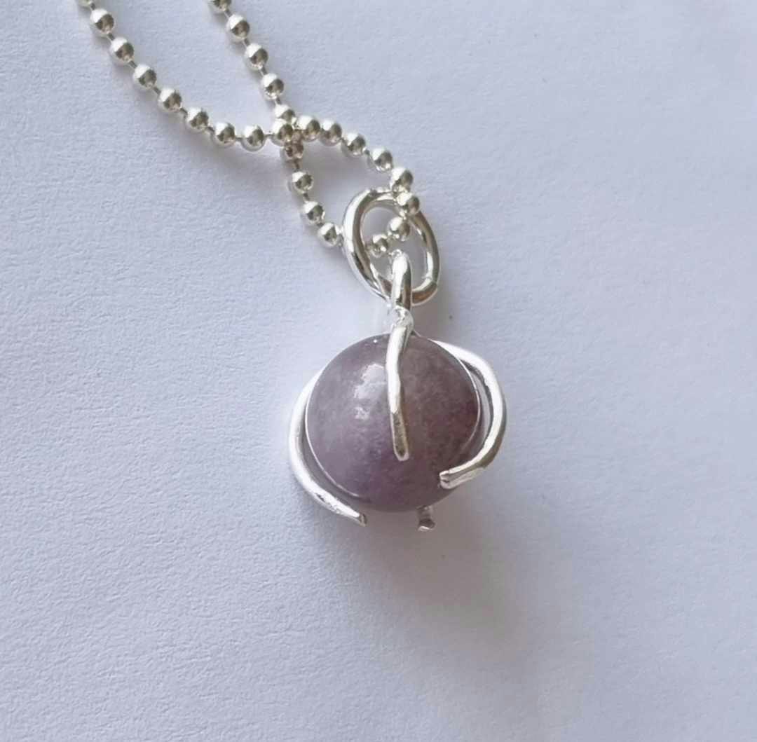 A nice necklace with a purple stone, round, set in sterling silver