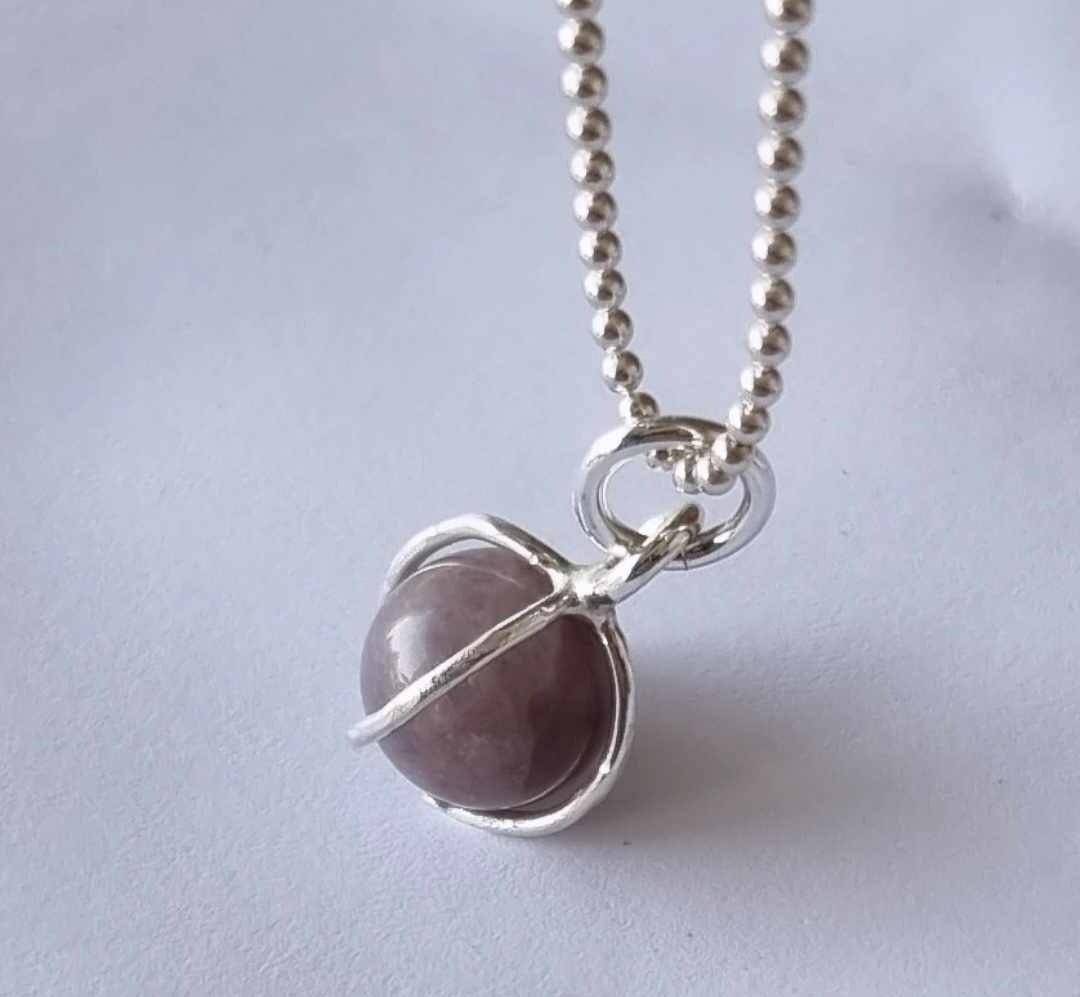 A nice necklace with a purple stone, round, set in sterling silver