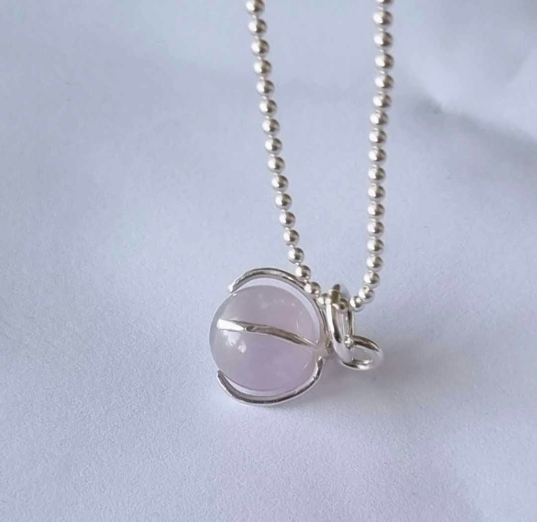 Ett fint halsband med en ljus lila/rosa sten, rund, infattad i äkta silver
