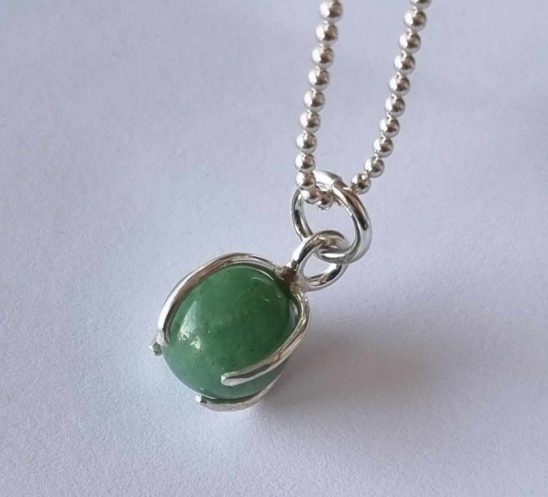 Ett fint halsband med en grön rund sten, infattad i äkta silver