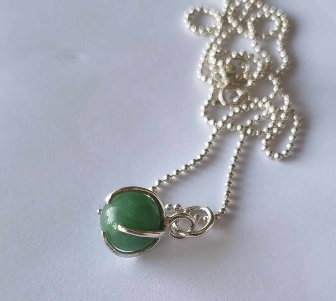 Ett fint halsband med en grön rund sten, infattad i äkta silver