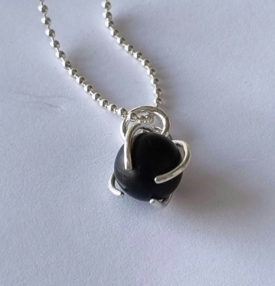 Ett fint halsband med en infattad rund svart sten, i äkta silver