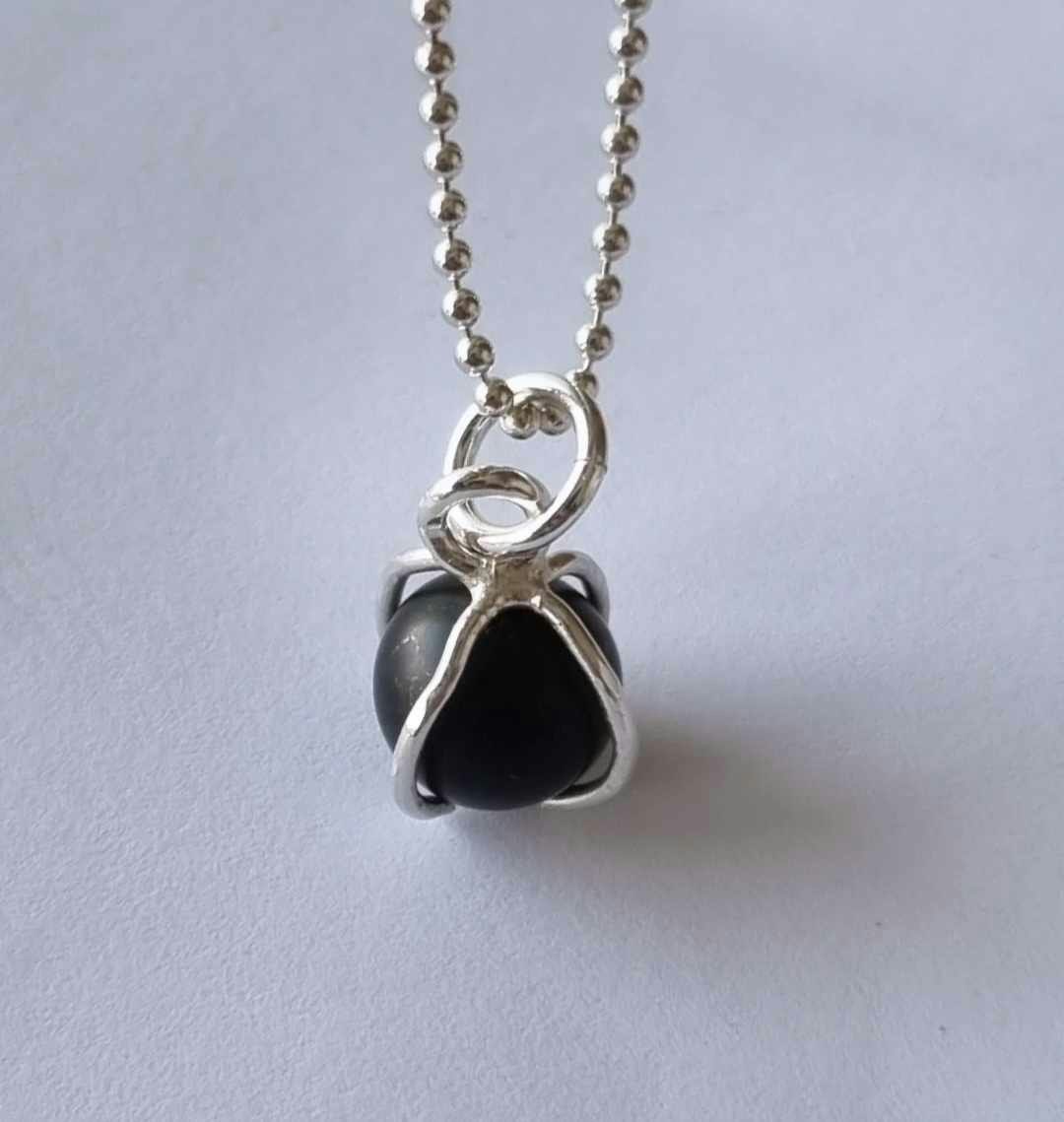 Ett fint halsband med en infattad rund svart sten, i äkta silver