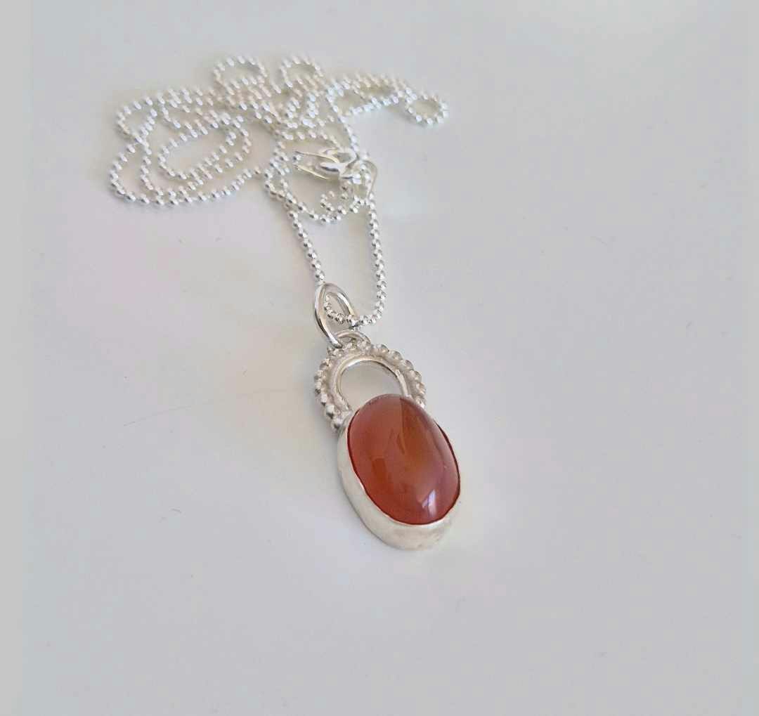 Cabochon med orange agat infattad i äkta silver