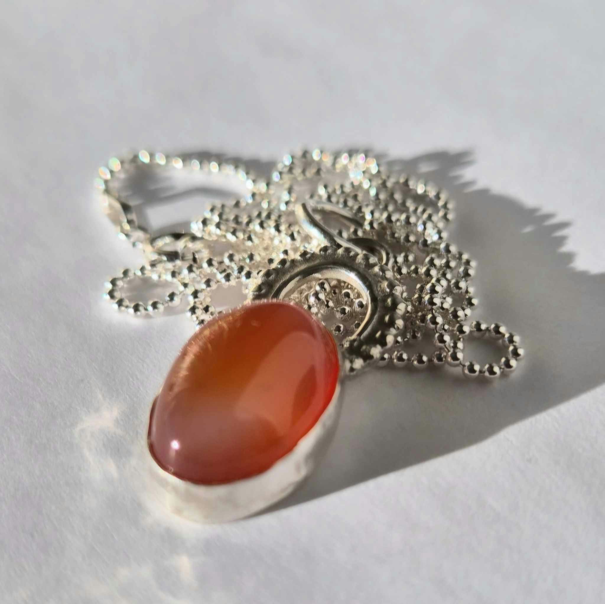 Cabochon med orange agat infattad i äkta silver