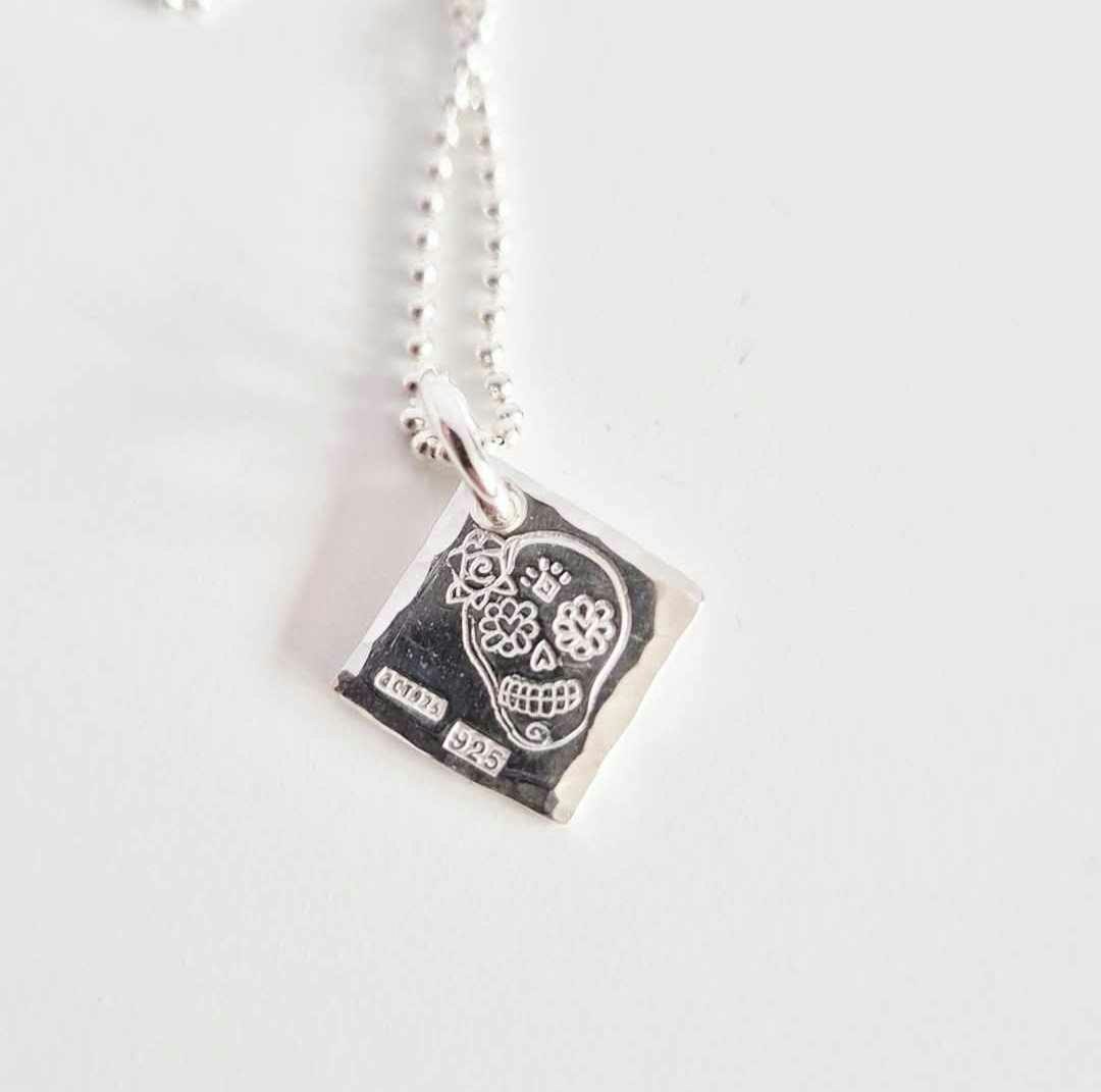 Ett fint silverhalsband med en döskalle i äkta silver HER på en silverbricka