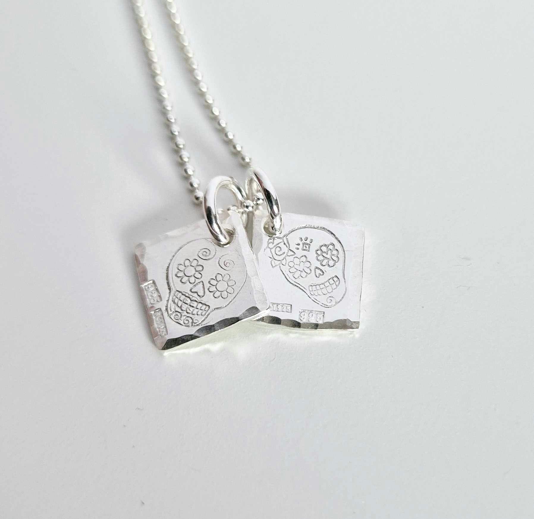 Ett fint silverhalsband med en döskalle i äkta silver HER på en silverbricka