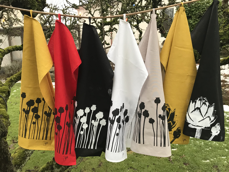 handdukar i olika färger med mönster av vallmokapslar