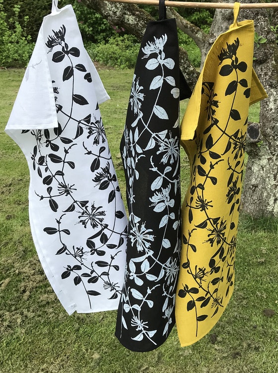 handdukar i olika färger med kaprifolmönster