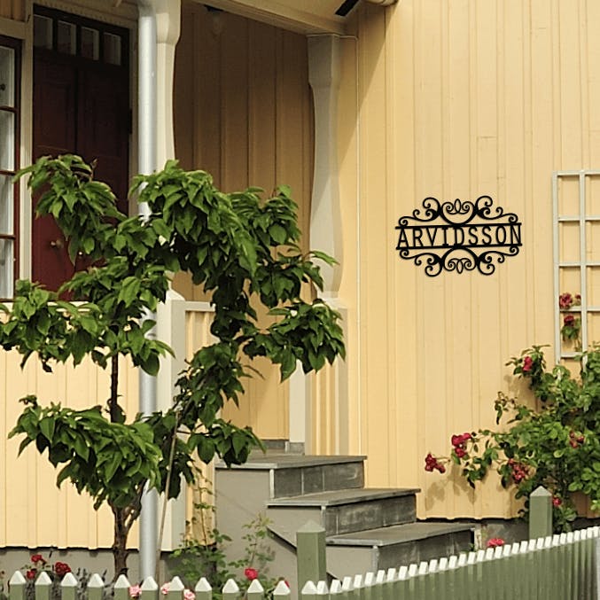 Personlig dekor med namnet Arvidsson, monterad på husfasad.