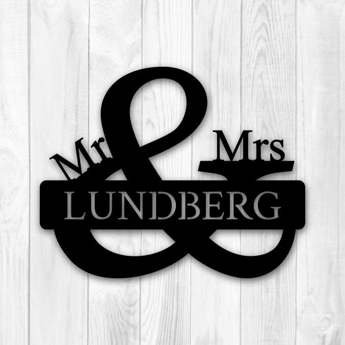 Skylt i metall utformad som ett &-tecken med texten Mr & Mrs Lundberg.