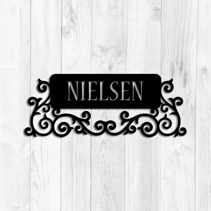 Snygg namndekor i svart plåt med namnet Nielsen.