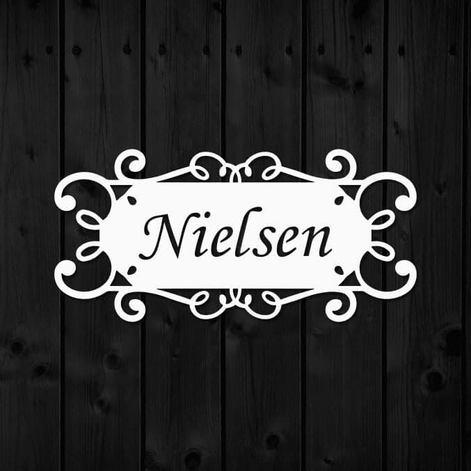 Namnskylt i metall med namnet Nielsen utskuret.