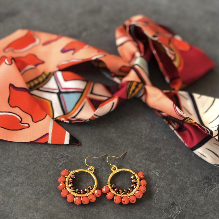 Runda handgjorda örhängen prydda med olika glaskristallpärlor i orange med twilly scarf