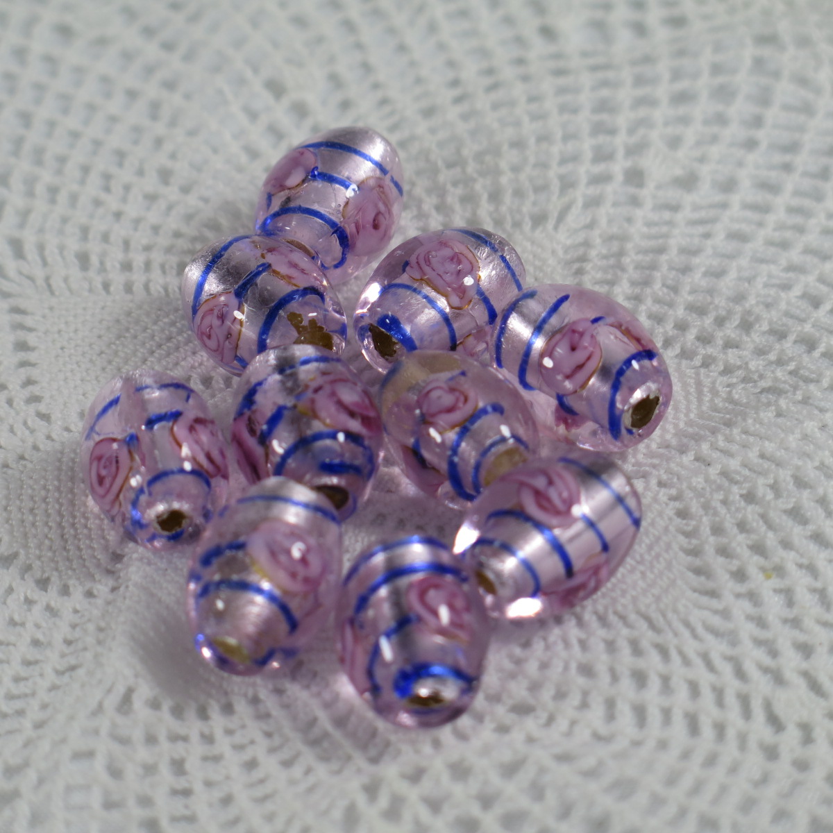 Ovala glaspärlor med blomma rosa med blå rand