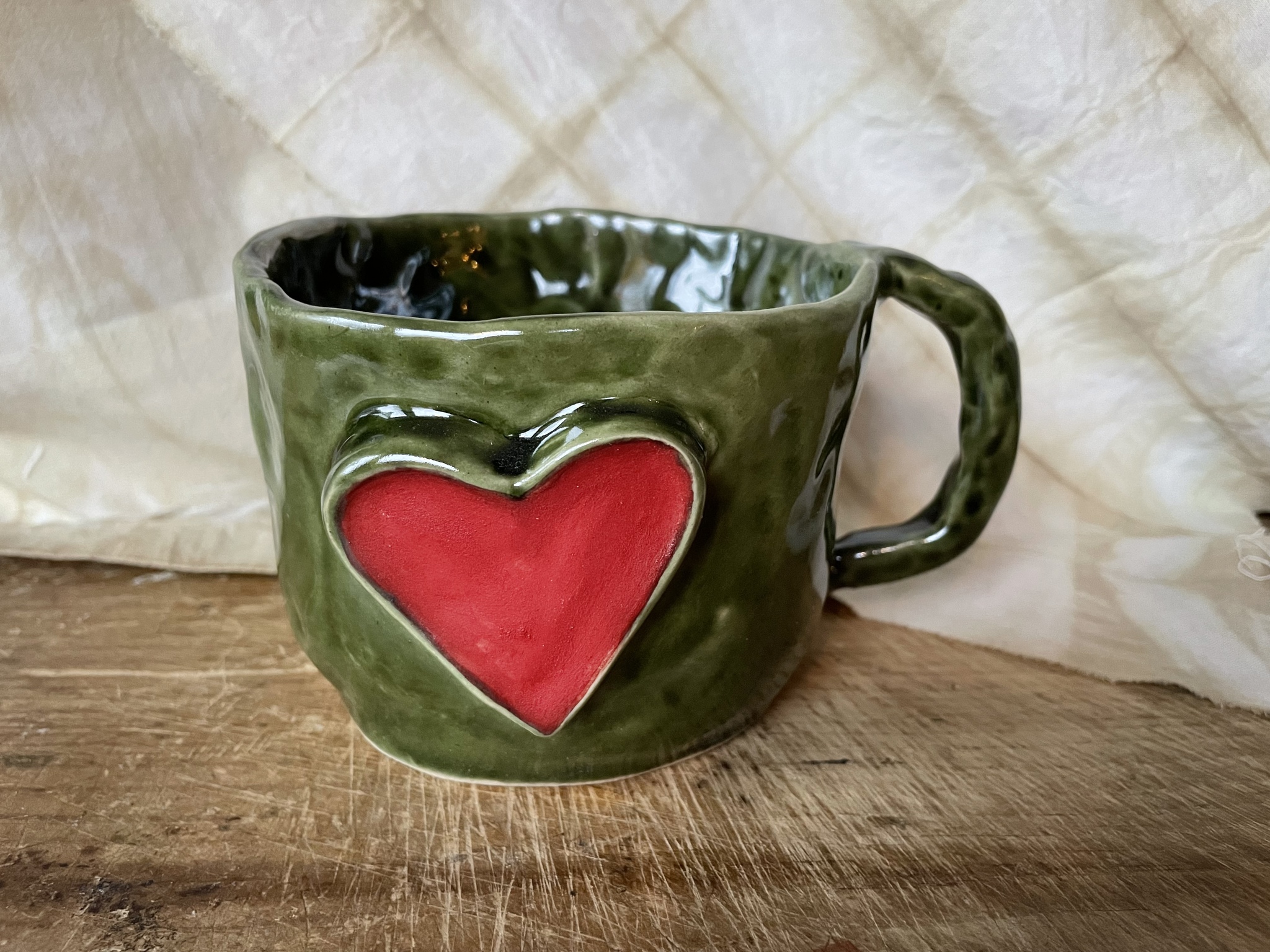 Grön tummad mugg med stort rött hjärta