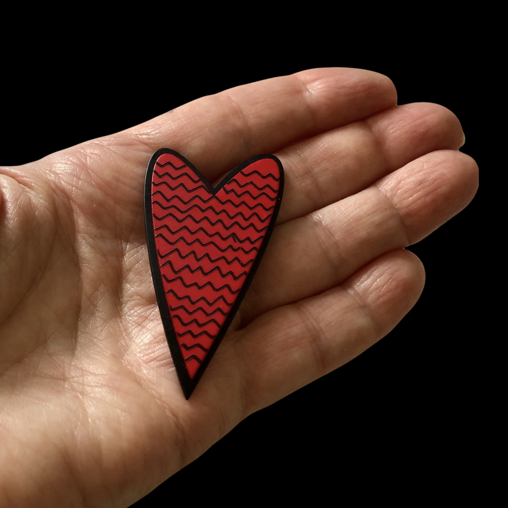 Stor brosch med rött vågmönstrat hjärta i plexi