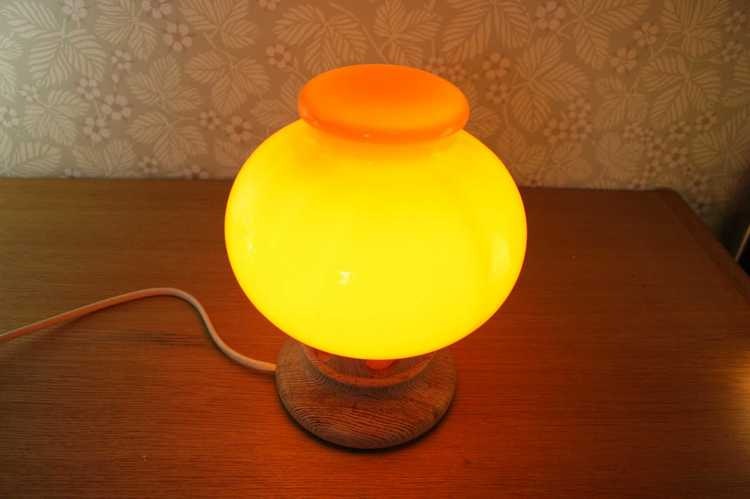 Bordslampa i orange glas och fot i furu tänd perspektiv