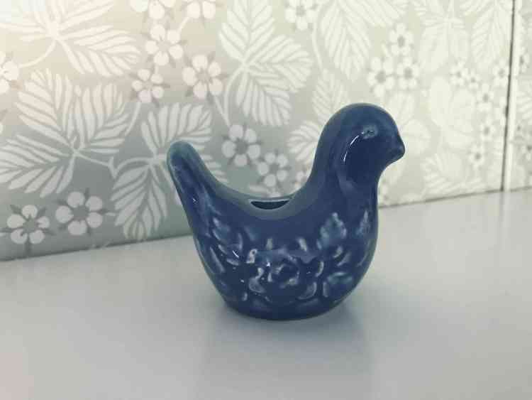 Ljusstake i keramik av blå fågel fotad från sidan