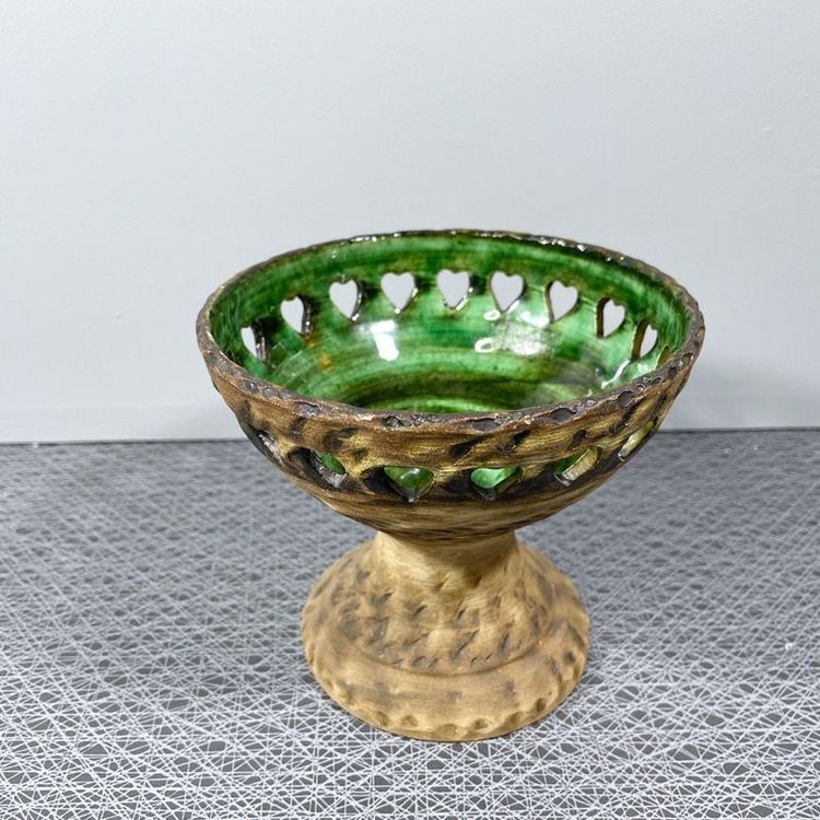 Ljusstake på fot i keramik med grön glasering och perforerad kant