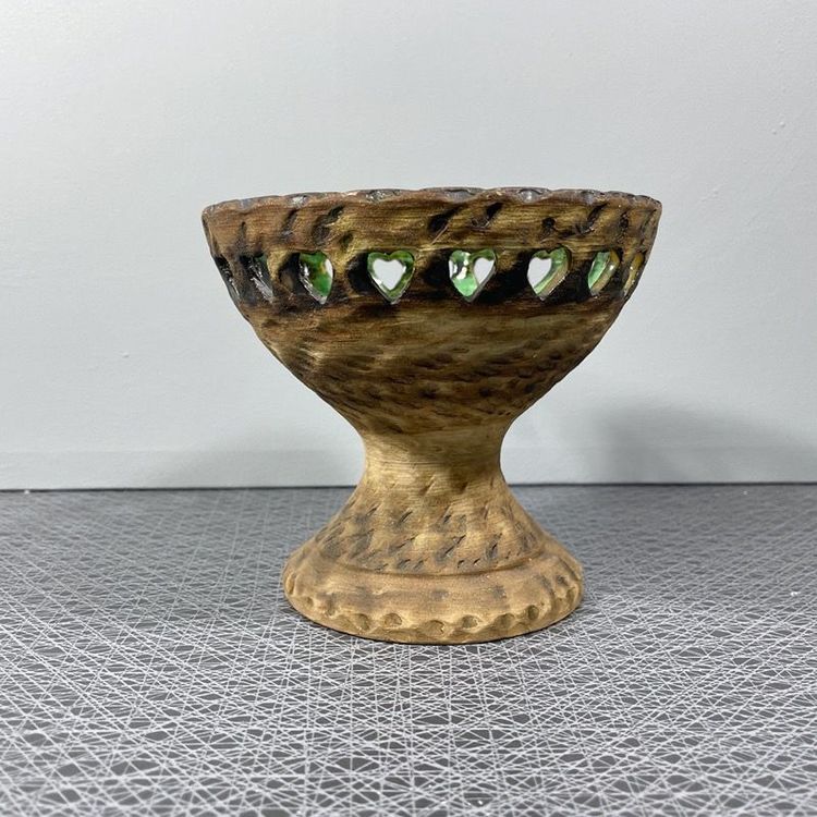 Ljusstake på fot i keramik med grön glasering och perforerad kant tagen framifrån