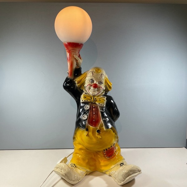 Bordslampa av Clown som håller i en lampa framifrån