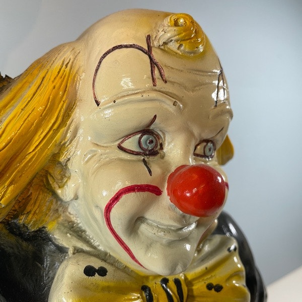 Bordslampa av Clown som håller i en lampa framifrån närbild clownansikte