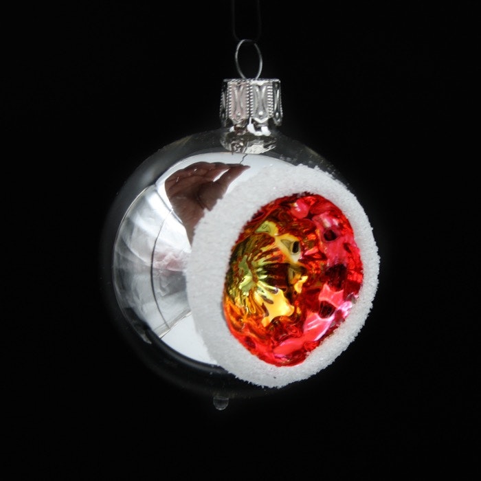 Äldre julgranskula i glas med reflektor