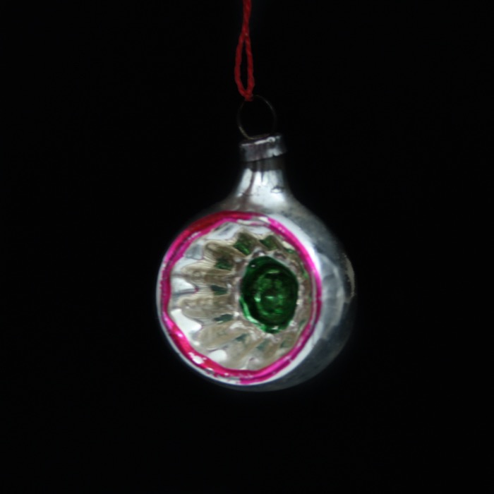 Äldre julgranskula i glas med reflektor och rosa kant