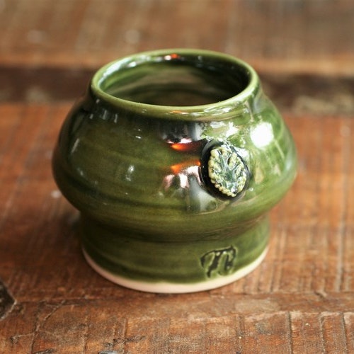 Liten grön vas med bladdekoration