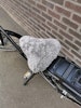 Cykelsadelskydd i fårskinn Grå på en el cykel tagen utomhus