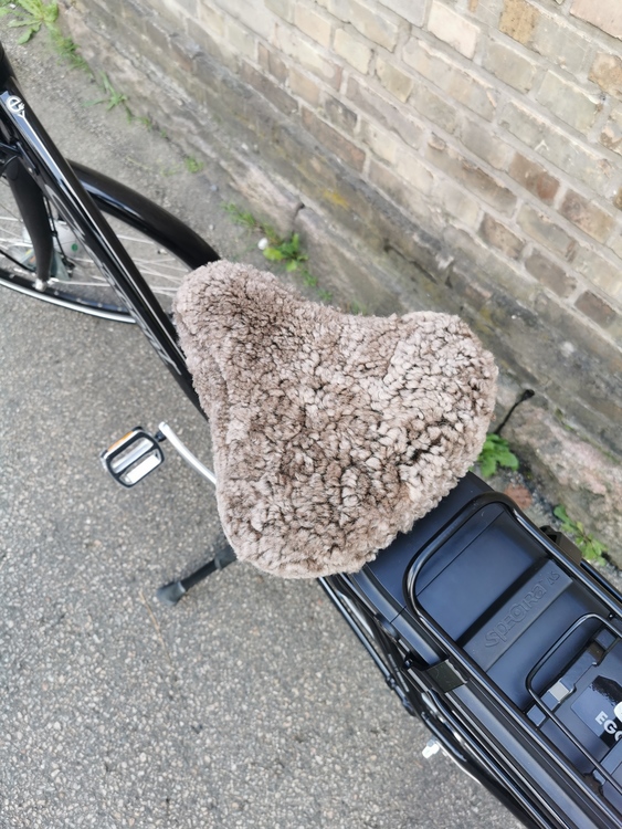 Cykelsadelskydd i fårskinn Brun på en cykel tagen utomhus