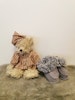 Fin teddybjörn och ett par babytofflor i grå färg