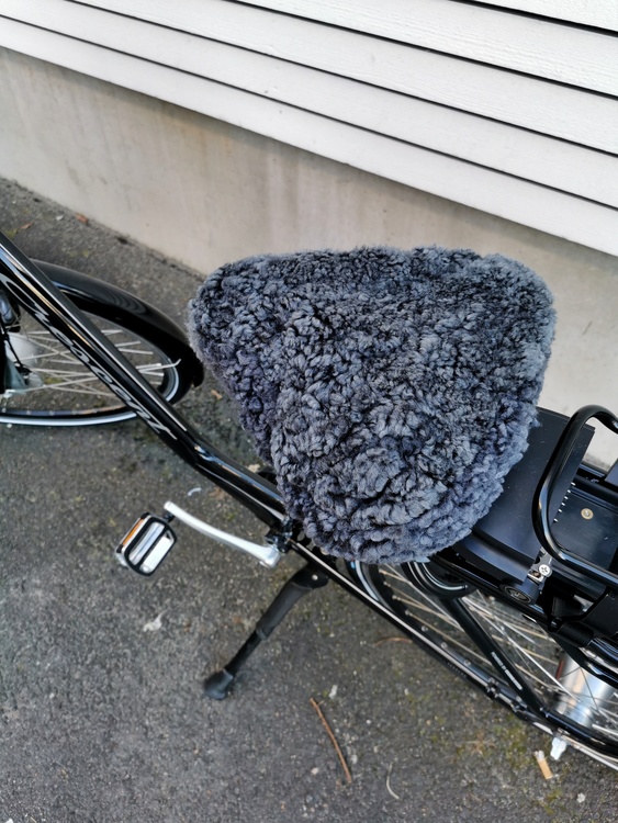 Snyggt cykelsadelskydd Grå närbild, skydde sitter på en el cykel